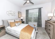 Thumbnail 7 of 38 - a bedroom with a bed and a ceiling fan