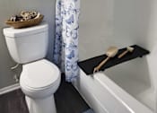 Thumbnail 25 of 31 - A white toilet sits next to a bathtub with a black tray on it  at Waterview at Rocky Point, Florida