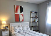 Thumbnail 23 of 31 - A bedroom with a bed, nightstand, and a shelf with books  at Waterview at Rocky Point, Florida