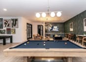 Thumbnail 17 of 38 - a pool table in a living room with a bar and a television