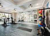 Thumbnail 11 of 34 - A spacious gym with exercise equipment and a mirrored wall.