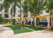 Thumbnail 17 of 35 - a courtyard with palm trees and yellow umbrellas in front of a building