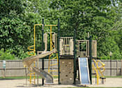 Thumbnail 14 of 27 - A playground with a yellow and grey slide.