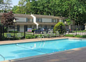 Thumbnail 2 of 27 - A pool with a diving board in front of a house.