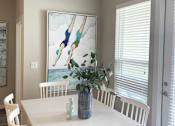 Thumbnail 11 of 50 - a dining room with a table and chairs and a painting on the wall