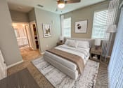 Thumbnail 17 of 31 - A bedroom with a large bed and a ceiling fan.