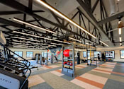 Thumbnail 34 of 43 - A gym with a variety of equipment including treadmills, weights, and exercise machines.
