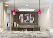 Thumbnail 10 of 20 - A kitchen with a marble countertop and black chairs.