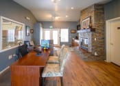 Thumbnail 4 of 43 - a home office with a wooden desk and a brick fireplace