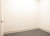 Thumbnail 50 of 54 - A room with a carpeted floor and a door.