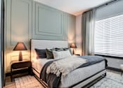 Thumbnail 8 of 26 - A bedroom with a large bed and two lamps.