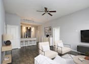 Thumbnail 9 of 31 - A living room with a white sofa, a black ceiling fan, and a black television.