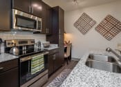 Thumbnail 18 of 37 - kitchen with granite counter tops and stainless steel appliances at the reserve at walnut creek