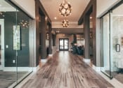 Thumbnail 2 of 37 - a long hallway with glass doors and a chandelier