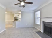 Thumbnail 16 of 27 - a living room with a fireplace and a ceiling fan at Crestmont at Thornblade, South Carolina