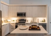 Thumbnail 9 of 22 - a kitchen with white cabinets and stainless steel appliances at Leena Plantation, Plantation, FL