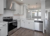 Thumbnail 15 of 27 - a kitchen with white cabinets and a black stove top oven