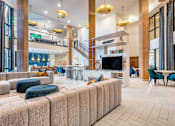 Thumbnail 2 of 29 - A large, modern living room with a staircase and a television.