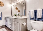 Thumbnail 20 of 29 - A bathroom with a white toilet and a white sink with a mirror above it.
