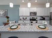 Thumbnail 3 of 23 - a kitchen with a large island with two plates on it