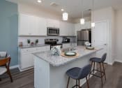 Thumbnail 1 of 23 - a kitchen with an island and two stools