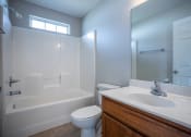 Thumbnail 17 of 26 - a bathroom with a white toilet next to a white bathtub