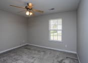 Thumbnail 23 of 26 - a bedroom with a ceiling fan and a window