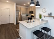 Thumbnail 1 of 32 - A kitchen with a white countertop and black bar stools.