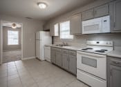 Thumbnail 2 of 26 - a kitchen with white appliances and white tile flooring