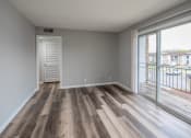 Thumbnail 7 of 25 - a bedroom with hardwood flooring and a sliding glass door leading to a balcony