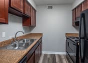 Thumbnail 5 of 25 - a kitchen with black appliances and brown cabinets