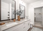 Thumbnail 25 of 50 - a white bathroom with two sinks and a mirror