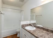 Thumbnail 18 of 35 - A bathroom with a sink, mirror, and toilet.
