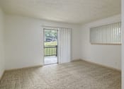 Thumbnail 17 of 35 - Empty room with carpeted floor and sliding glass door.