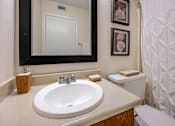Thumbnail 13 of 30 - A bathroom with a sink, mirror, and toilet.