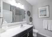 Thumbnail 8 of 41 - A bathroom with a white sink and a white toilet.