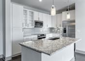 Thumbnail 15 of 36 - A modern kitchen with granite countertops and stainless steel appliances.