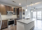 Thumbnail 19 of 36 - A modern kitchen with a large island and stainless steel appliances.