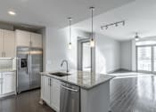 Thumbnail 20 of 36 - A modern kitchen with stainless steel appliances and a marble countertop.