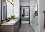 Thumbnail 12 of 46 - a bathroom with a sink and a shower and a bedroom