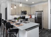 Thumbnail 13 of 46 - a kitchen with a large island and a stainless steel refrigerator