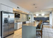 Thumbnail 6 of 35 - a kitchen with stainless steel appliances and a long island with chairs