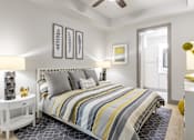 Thumbnail 17 of 36 - Midtown Atlanta, GA Luxury Apartments with In-Unit Washer and Dryer - Trace Midtown - Bedroom with Carpet Flooring, Area Rug, Large Bed, Nightstands with Lamps, Dresser, Ceiling Fan, and Attached Bathroom.