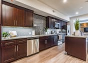 Thumbnail 8 of 35 - a kitchen with wooden cabinets and stainless steel appliances
