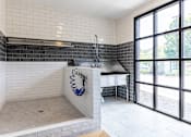 Thumbnail 43 of 46 - a large white tiled bathroom with a sink and a window