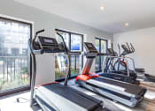 Thumbnail 14 of 35 - two treadmills and other exercise equipment in an apartment gym