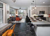 Thumbnail 7 of 46 - a kitchen and living room with a table and chairs