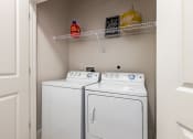 Thumbnail 23 of 35 - a washer and dryer in a small laundry room with a shelf above them