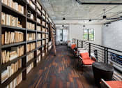 Thumbnail 34 of 46 - a library with a row of chairs and bookshelves