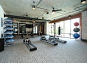 Thumbnail 32 of 46 - Duluth, GA Pet-Friendly Apartments - District at Duluth - Fitness Center with Carpeted Floor, Rowing Machines, Exercise Balls, Stationary Bikes, Free Weights, Expansive Mirrors, and Window Wall.